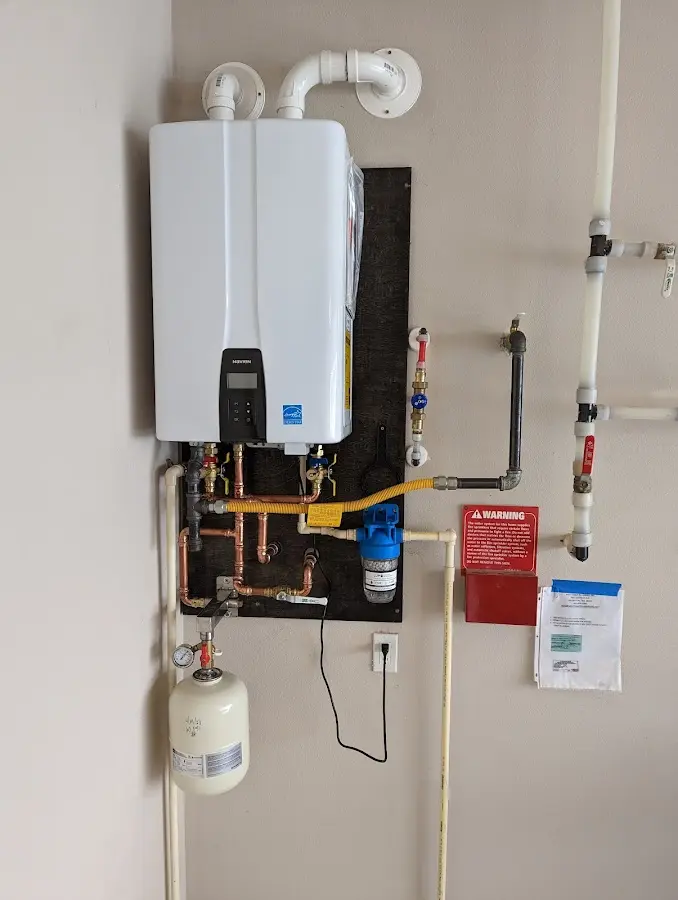 Professional plumber installing copper piping in a Poteau home